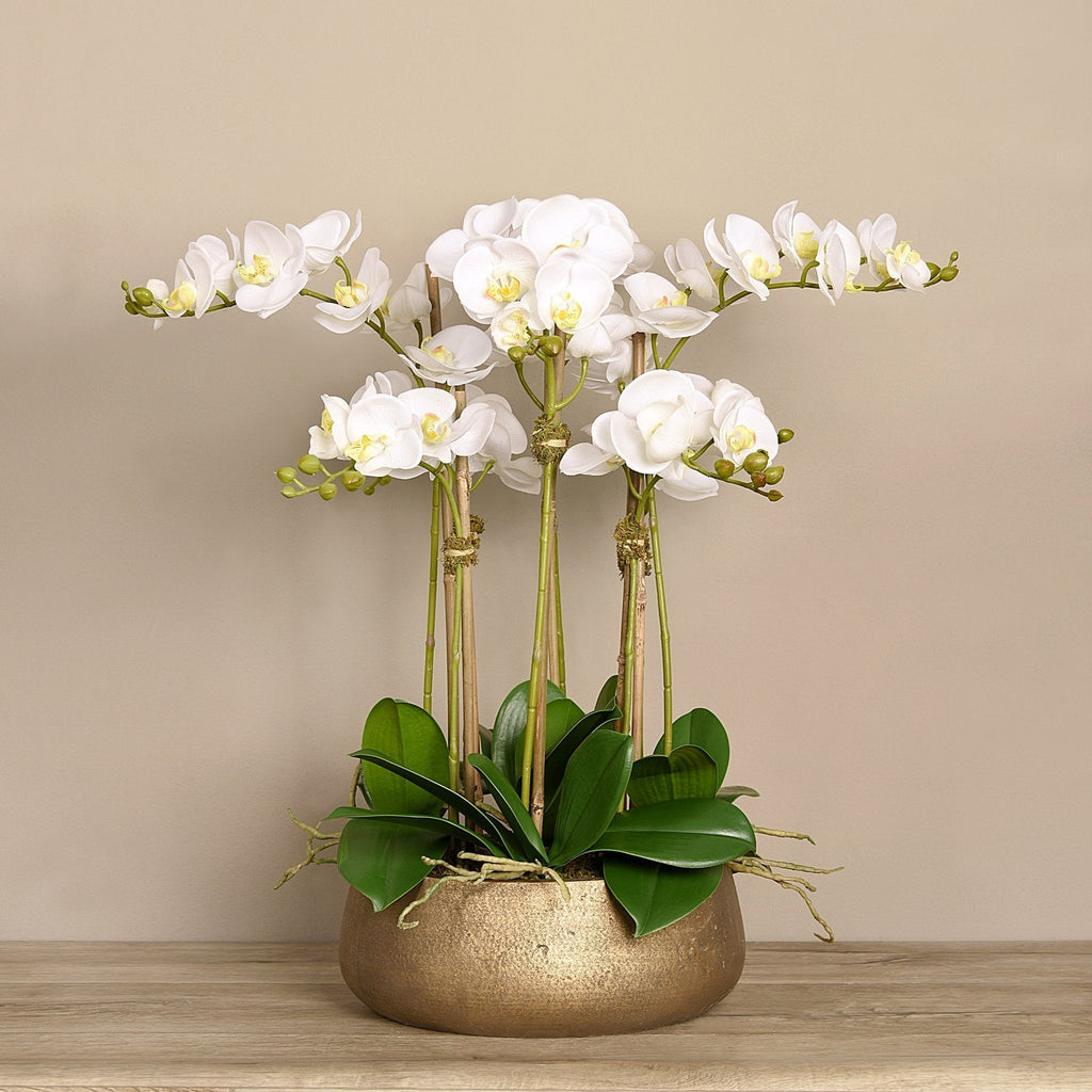 Faux white orchid arrangement in matte gold planter