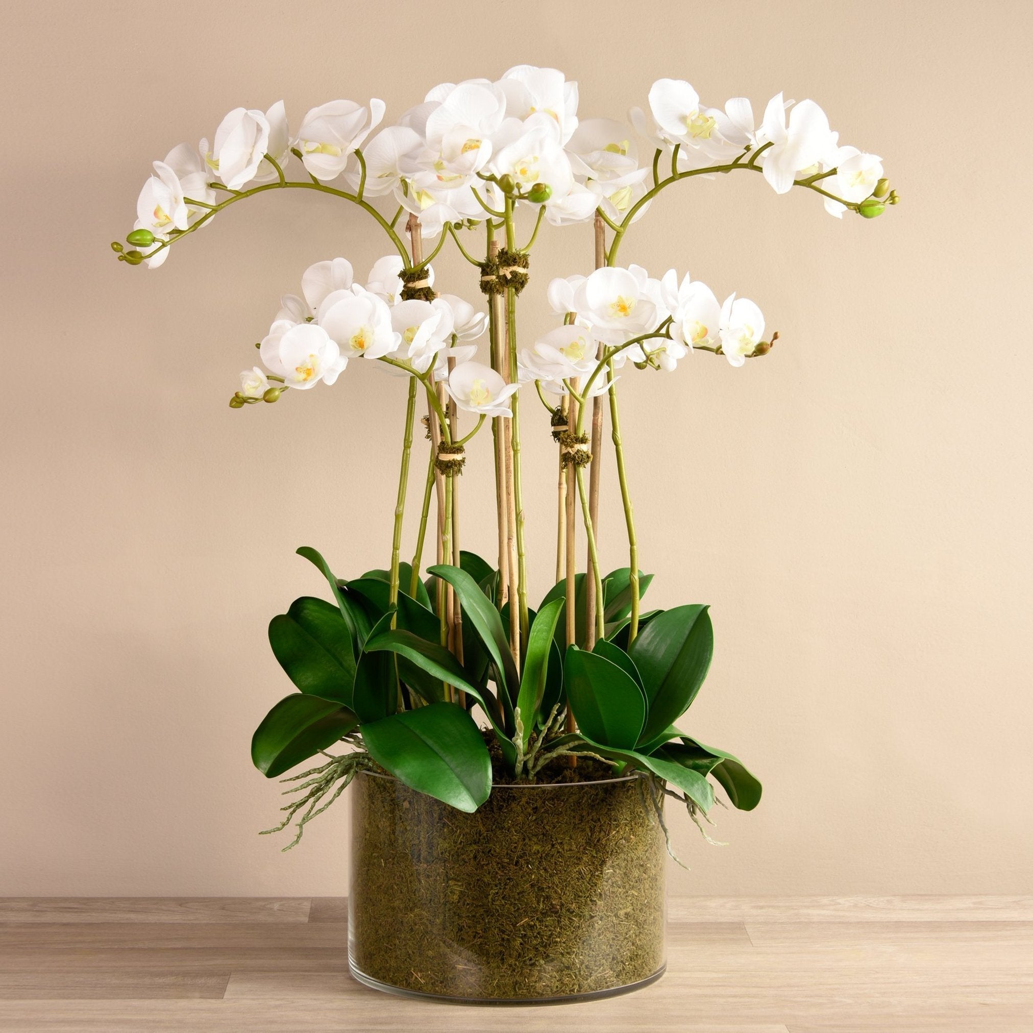 Large faux white orchid arrangement in glass vase